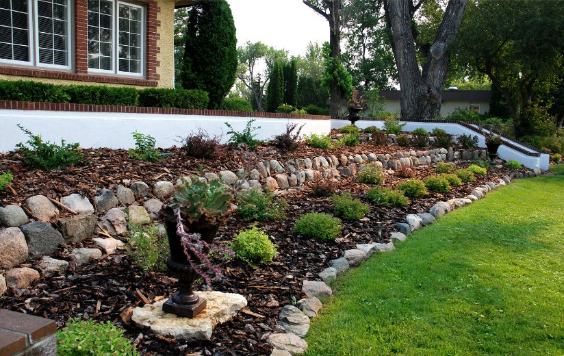Garden bed with a stone border beside a lawn