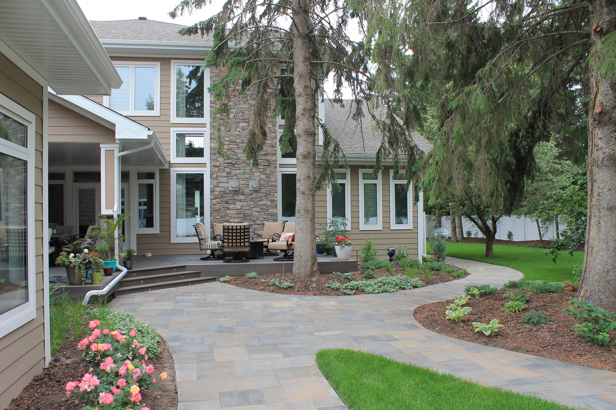 Finished backyard with a curved paving stone walkway and patio